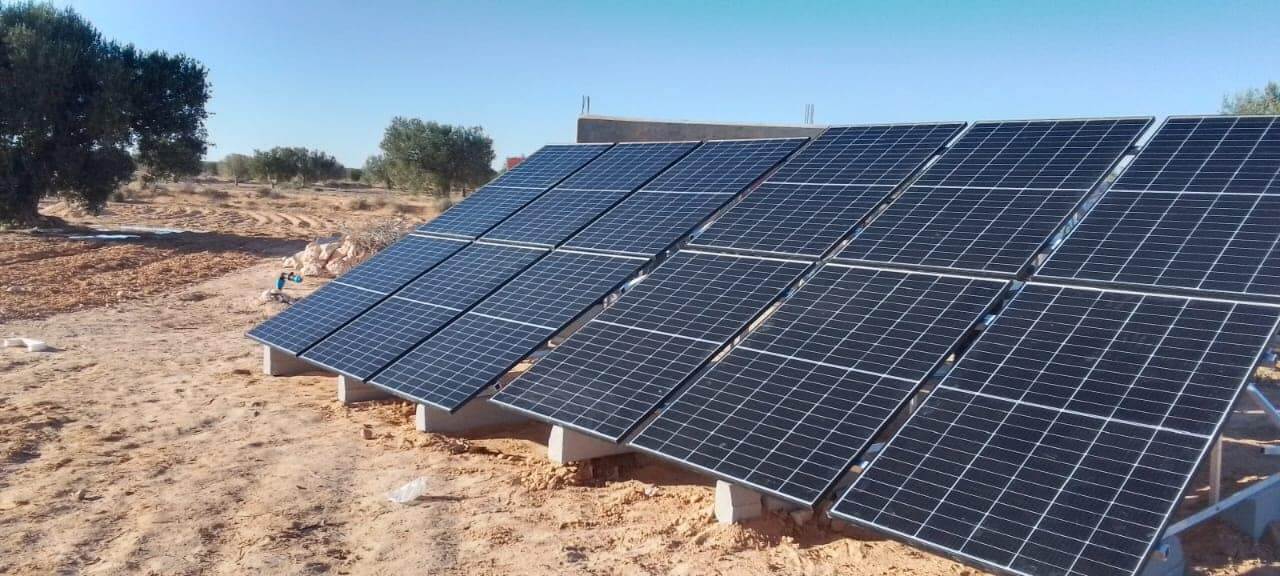 Technicien installant des panneaux solaires sur un toit en Tunisie pour une énergie propre et durable