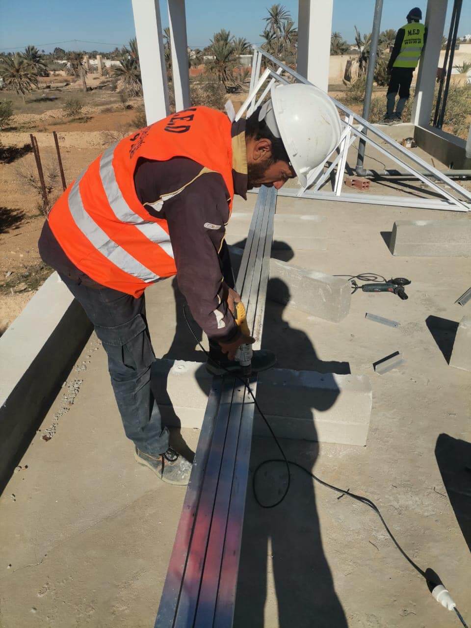 Technicien installant des panneaux solaires sur un toit en Tunisie pour une énergie propre et durable